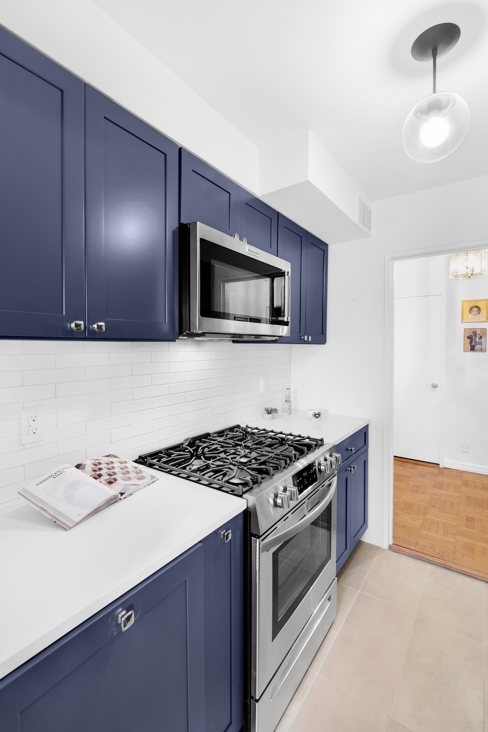 Luxury navy blue shaker kitchen with white quartz counters and classic subway tile backsplash – complete gut renovation in Murray Hill, Manhattan by SABI Construction
